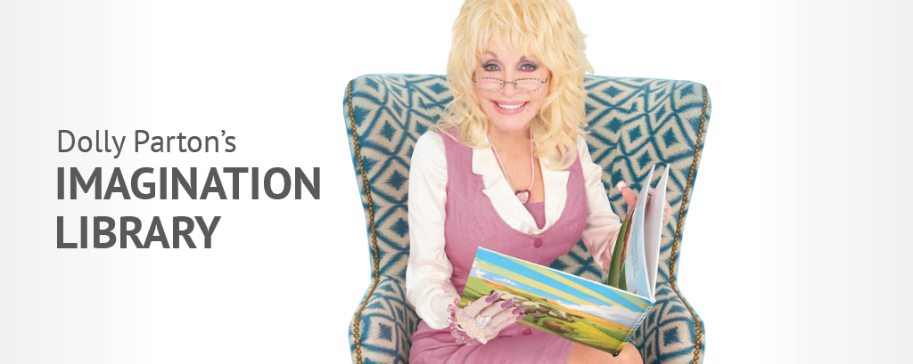 Dolly Parton sits in a patterned chair holding a book