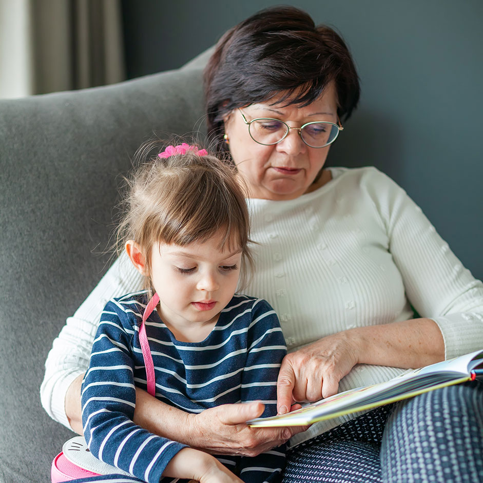 A grandmother reads to her grandchild
